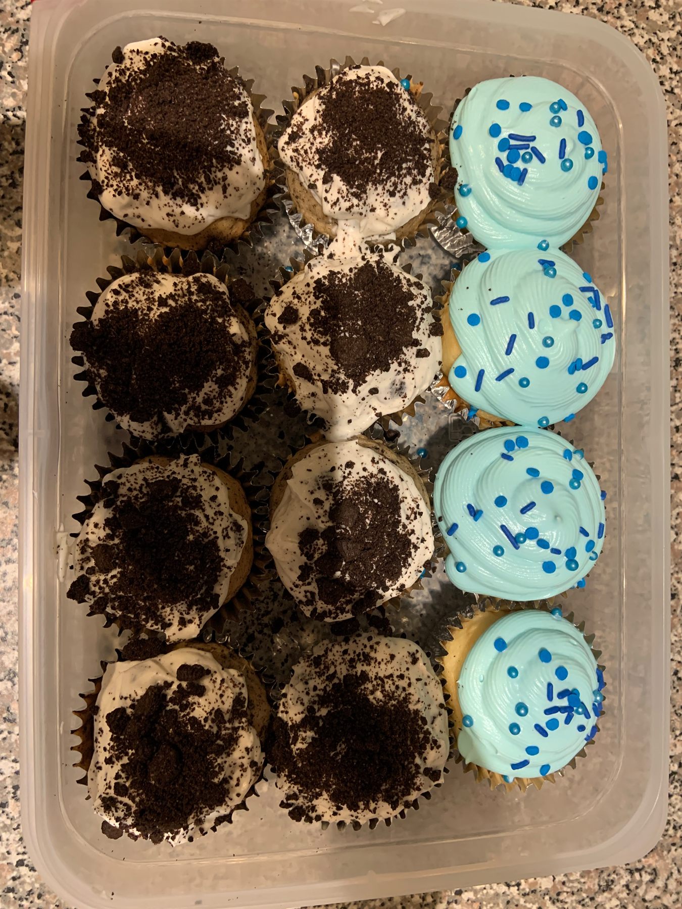 Tray of gender reveal cupcakes — cookies-and-cream topped cupcakes beside pale blue frosted cupcakes with blue sprinkles